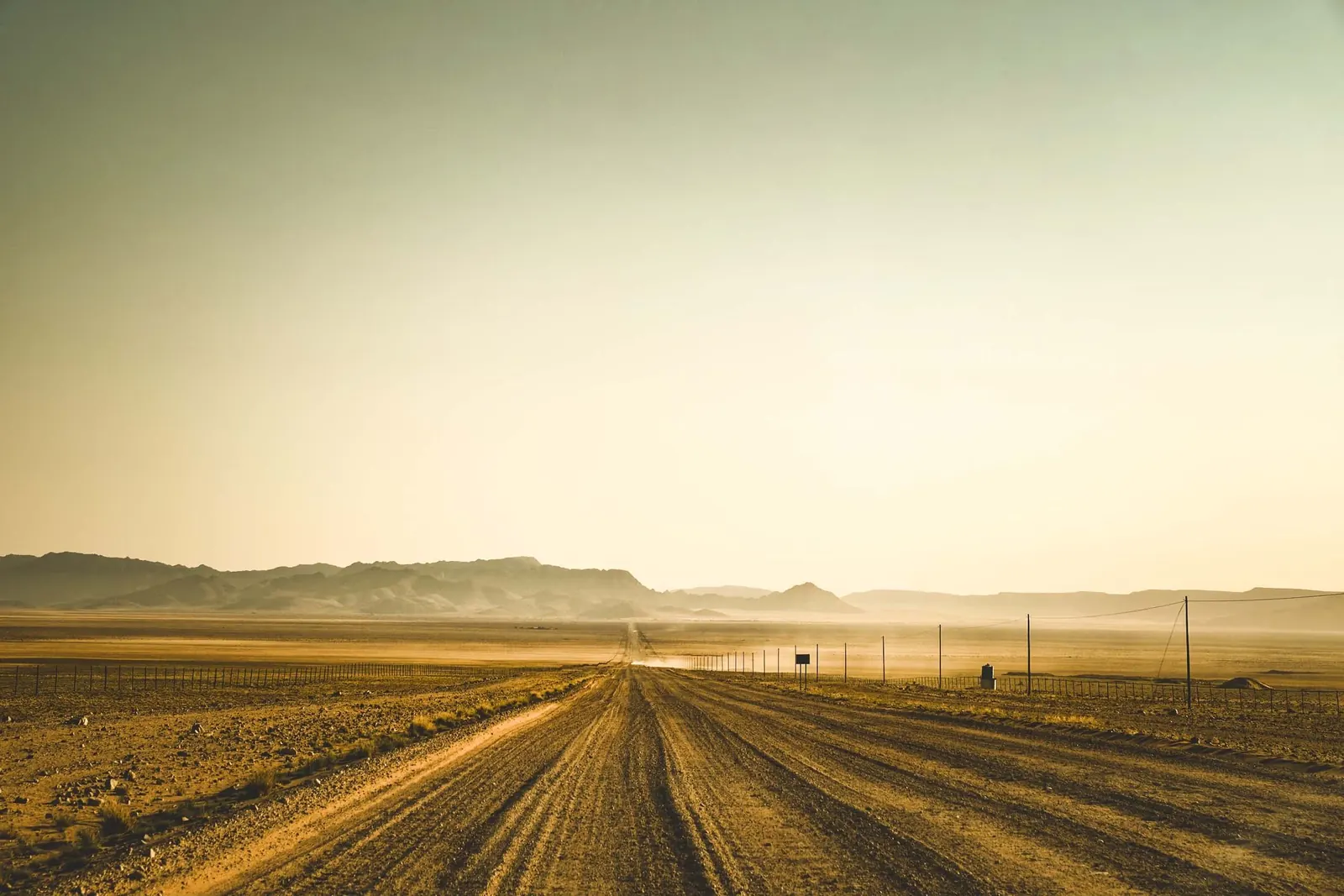 A 4x4 driving a gravel road through open Namibian country